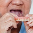 A woman who’s just removed her denture