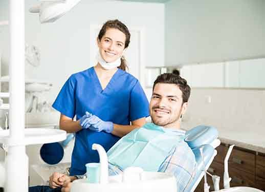 Patient and dentist smiling together in treatment room