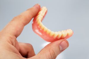 hand holding lower denture